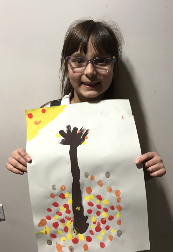 A child showing their art work.