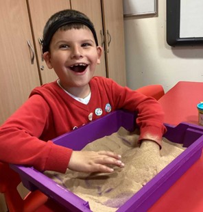 Child playing with sand in SRP Unit